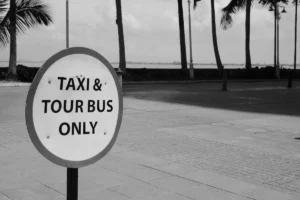 A black and white photo of a taxi and tour bus only sign