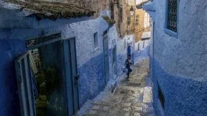 Boy running down a sloping street in Chefchaouen