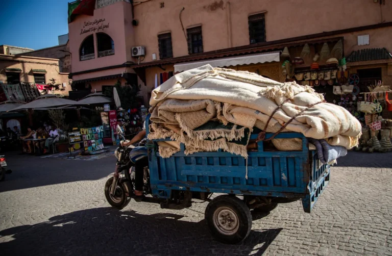 Blue motorized cart overloaded with goods on street