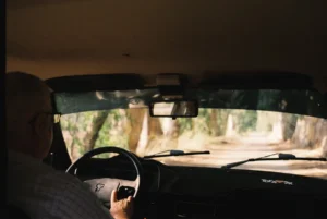 a man driving a car down a dirt road
