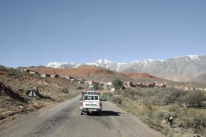 a white truck on a road with mountains in the background