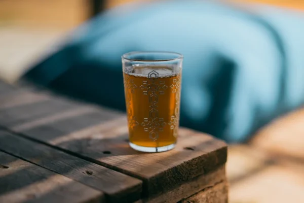 Bubbly drink in a glass on a wooden surface.