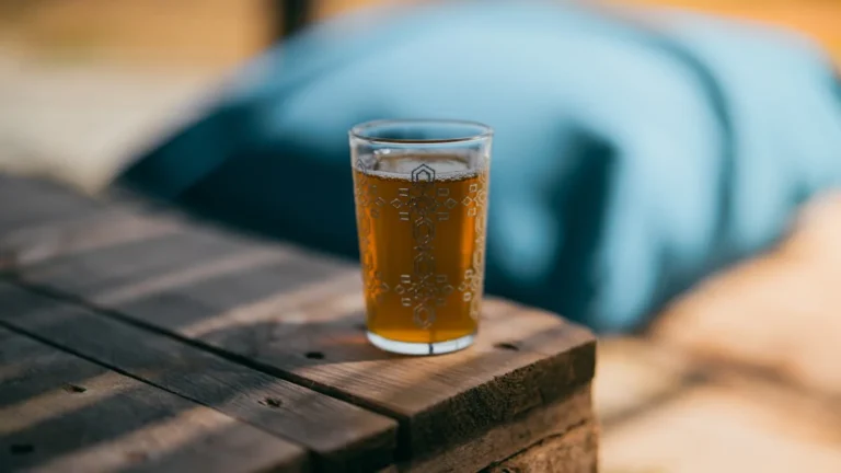 Bubbly drink in a glass on a wooden surface.