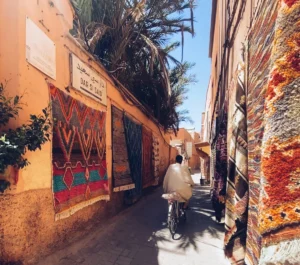 a man riding a bike down a narrow street