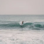 A person riding a surfboard on a wave in the ocean