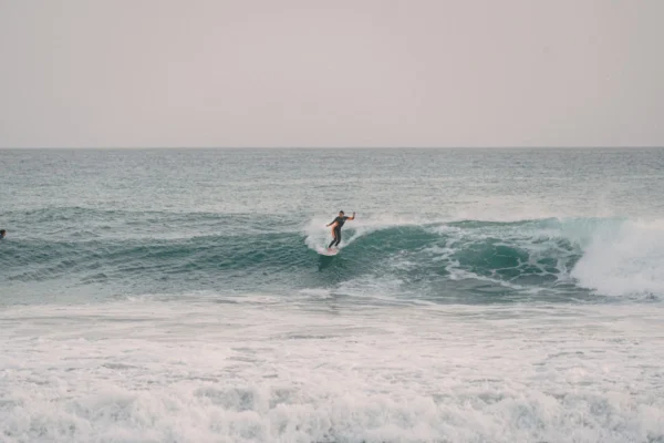 A person riding a surfboard on a wave in the ocean