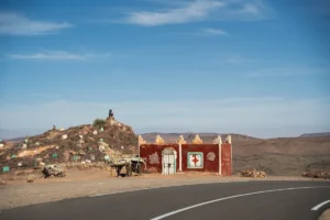 Small roadside structure with a hill covered in stones.