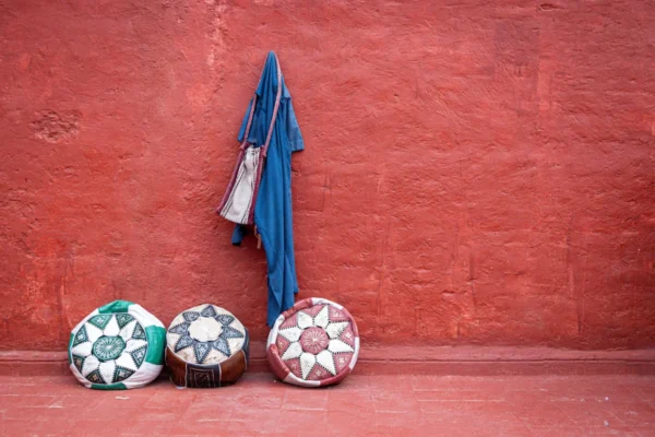 A group of three balls sitting next to a red wall
